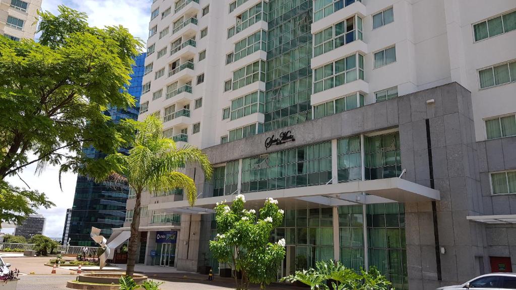 a tall white building with trees in front of it at Saint Moritz - flat particular a 05 min da Esplanada in Brasília