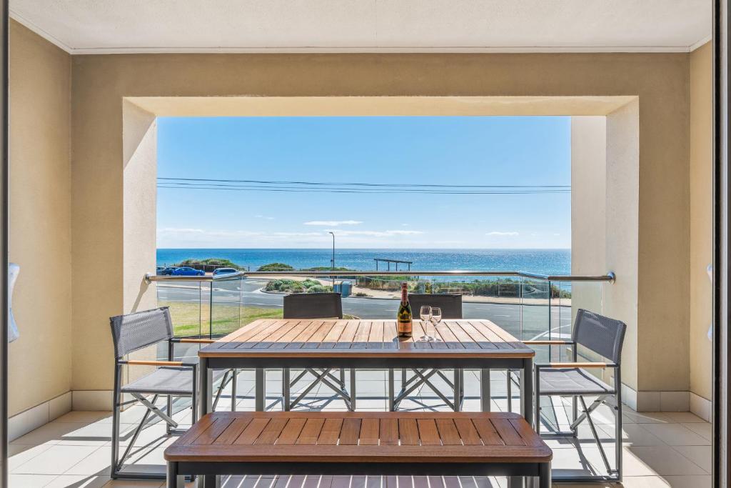 balcón con mesa, sillas y vistas al océano en Sea Star - Aldinga Beach - C21 SouthCoast Holidays, en Aldinga Beach