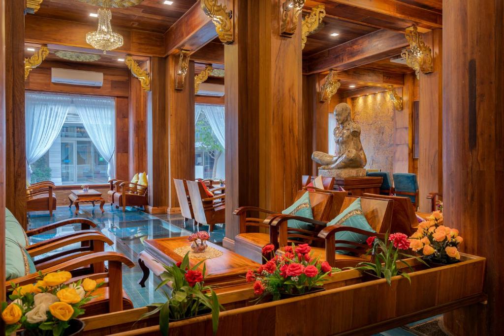 uma sala de estar com uma mesa e uma estátua em Ta Prohm Hotel & Spa em Siem Reap