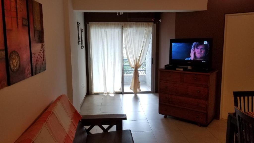 un soggiorno con TV su un comò con finestra di Departamento en el Punto 0 de San Juan con Cochera a San Juan