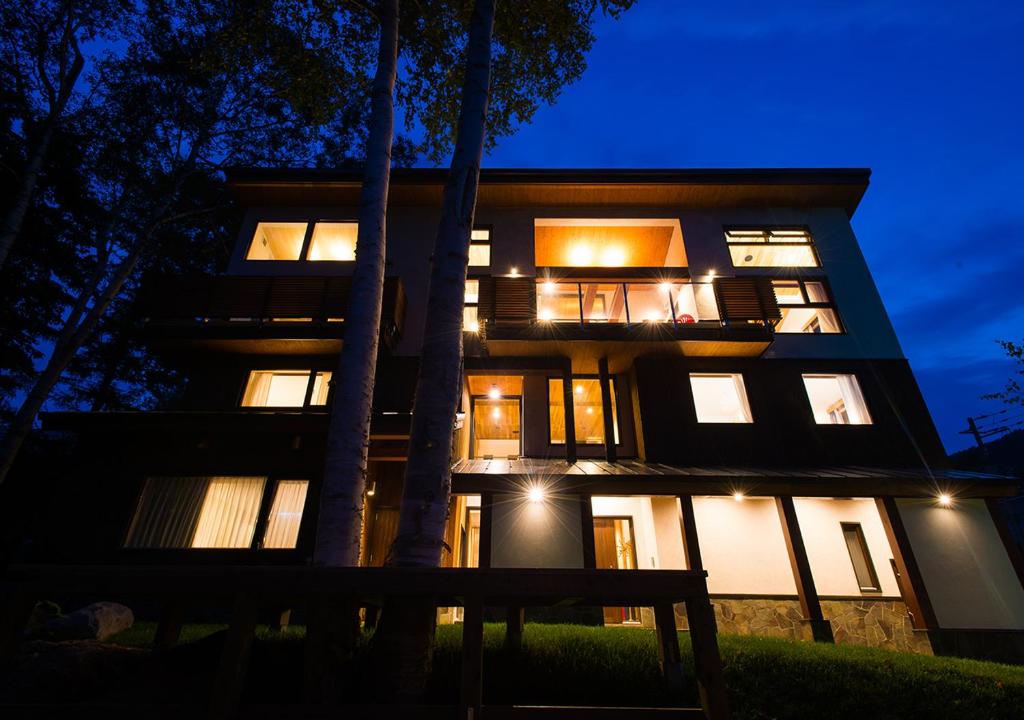 a large building with lights on at night at NISEKO REISE HOUSE ニセコライゼハウス in Kutchan