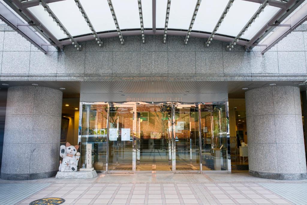 un edificio con una puerta de cristal delante de él en Sunny Stone Hotel, en Osaka