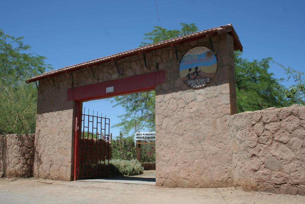 a building with a red door with a sign on it at Quinta Adela Bed & Breakfast in San Pedro de Atacama