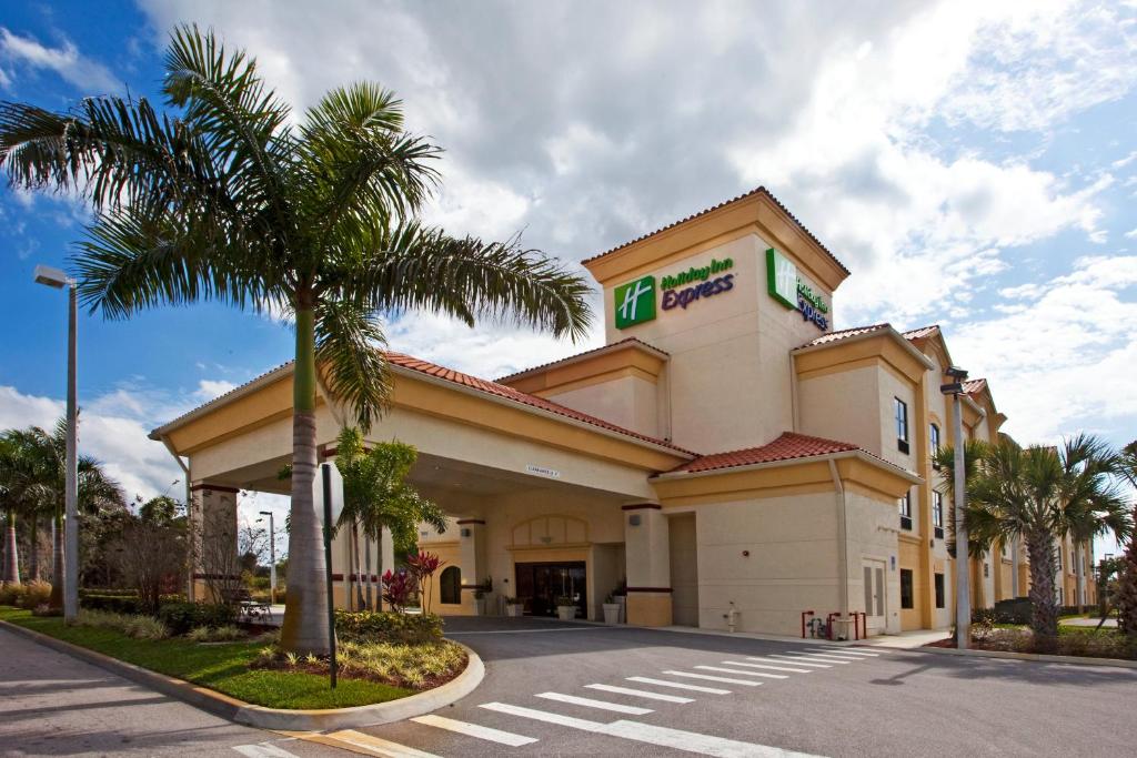 a hotel with a palm tree in front of a building at Holiday Inn Express Stuart, an IHG Hotel in Stuart