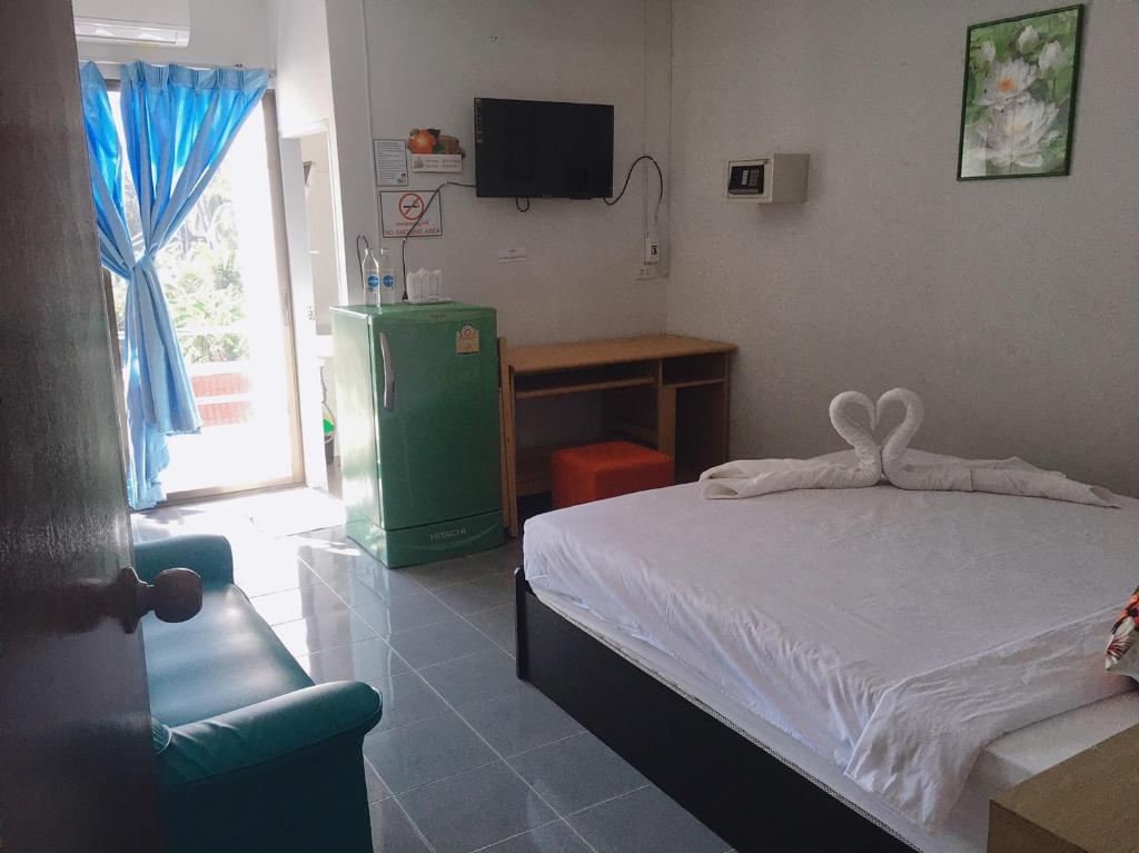 a bedroom with a bed and a television and a desk at Jenny Hostel HuaHin in Hua Hin