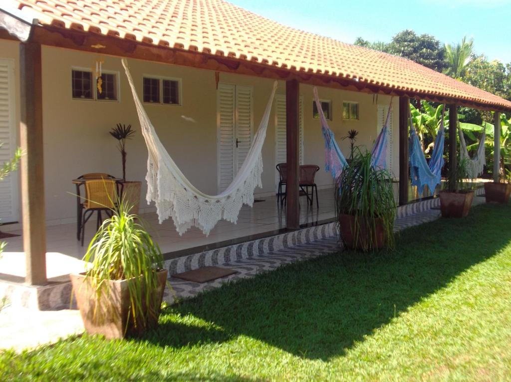 uma casa com um alpendre com plantas no quintal em Pousada Kekanto em Olímpia