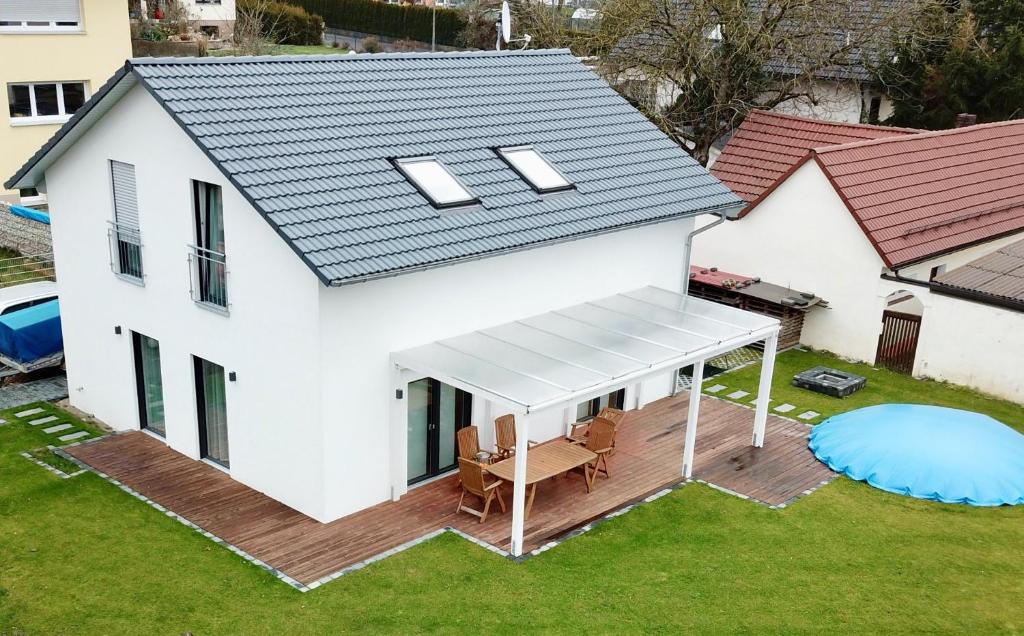 einen Blick über ein weißes Haus mit einer Terrasse in der Unterkunft HausGregor, Messe 15 min, City 20 min und Erholung im Grünen in Winkelhaid