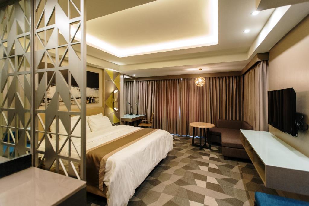 Habitación de hotel con cama y escritorio en Zuri Hotel en Iloilo