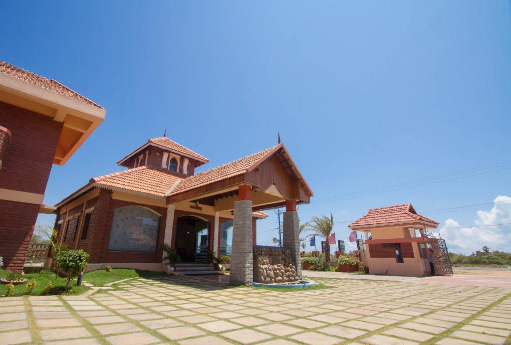 a house with a tile roof on a driveway at G S Resort in Velankanni