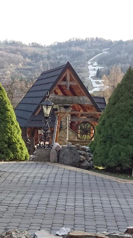 Cabaña de madera con techo negro en APARTAMENTY u KOWALA, en Szczawnica
