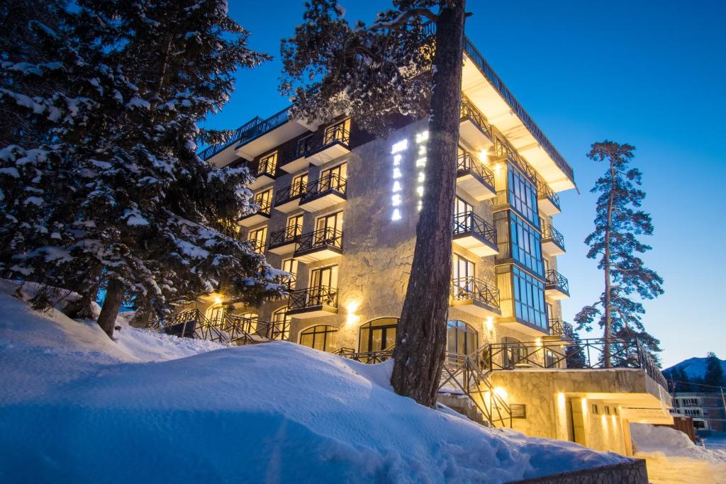 un gran edificio en la nieve por la noche en BM Plaza, en Bakuriani