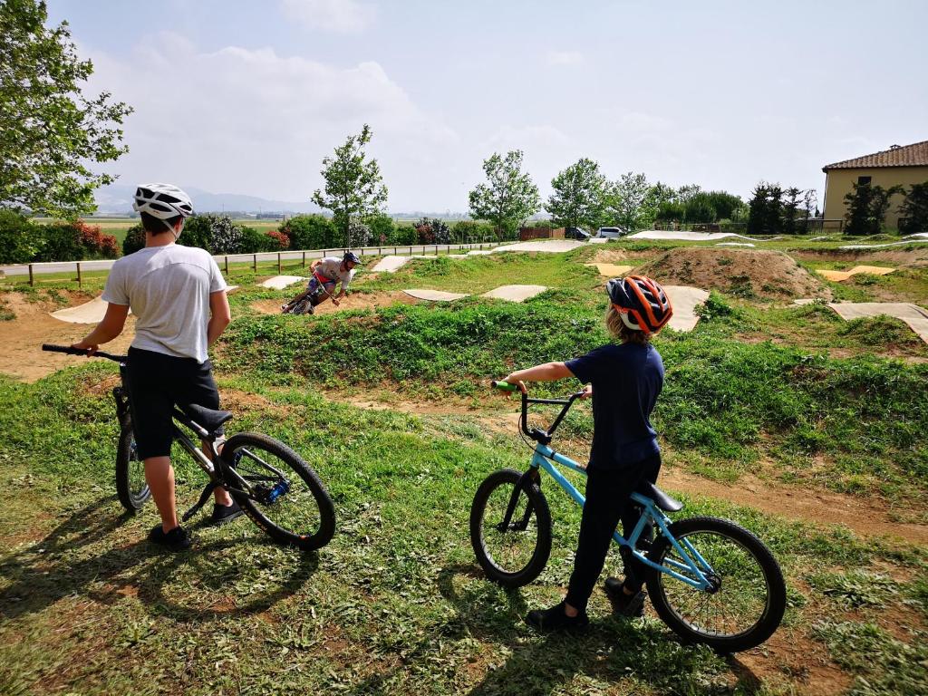 two people are standing with bikes in a field at Poggio all'Agnello Sport & Family Holidays in Populonia