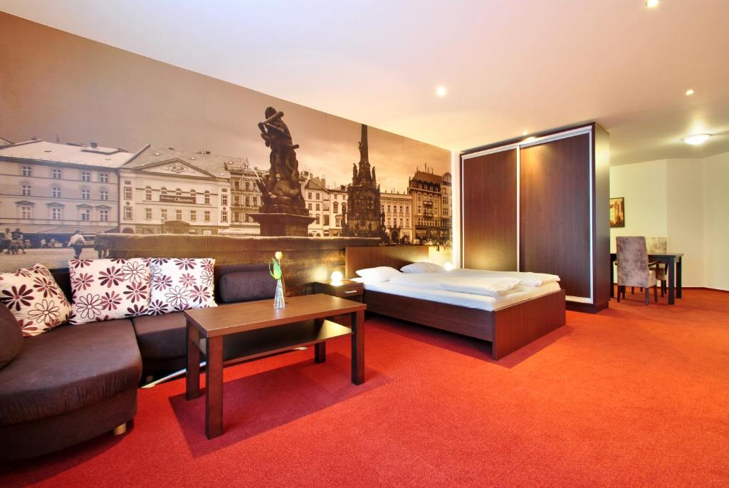 オロモウツにあるホテル パラースのベッドとソファ付きのホテルルーム