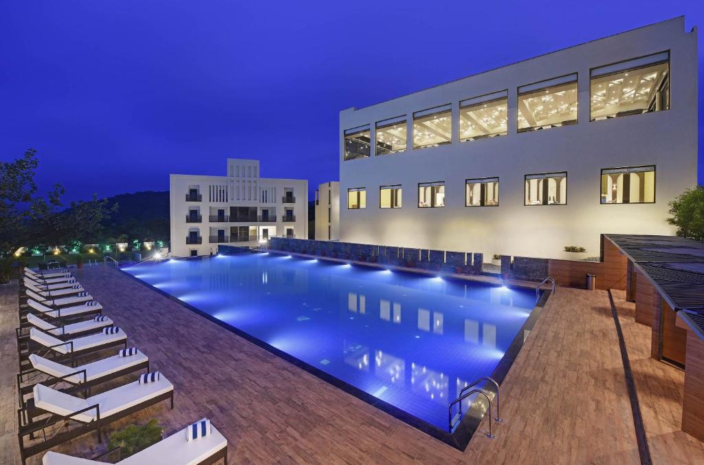 a swimming pool in front of a building at night at The Kumbha Residency by Trulyy - A Luxury Resort and Spa in Kumbhalgarh