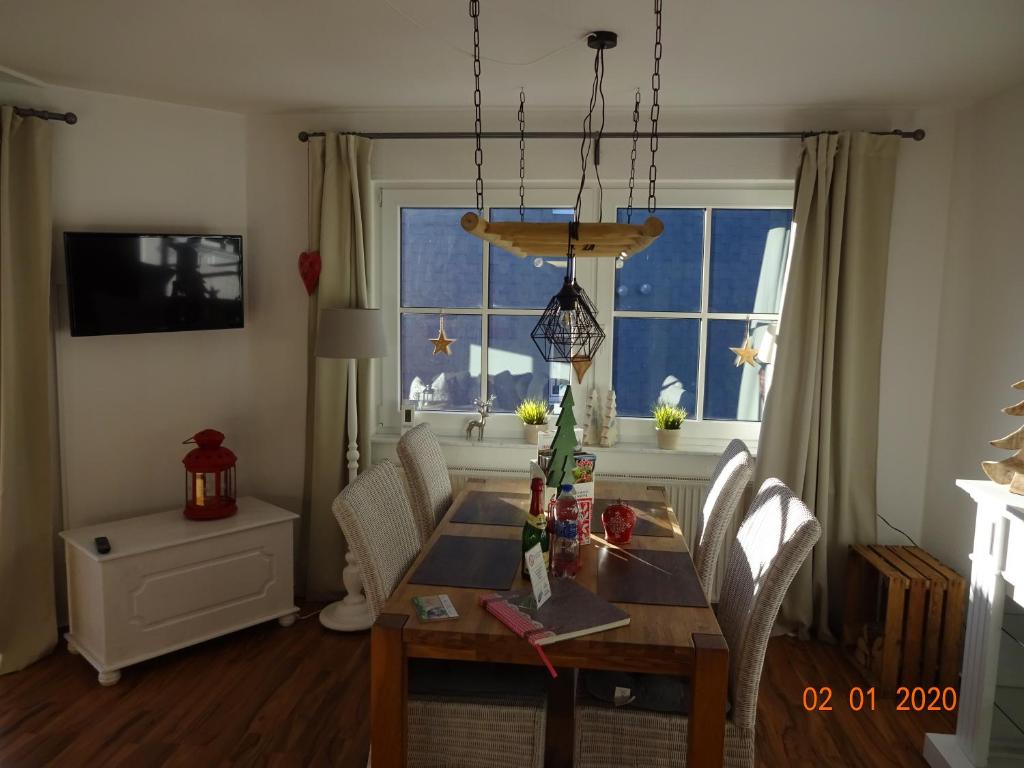 ein Esszimmer mit einem Tisch und einem Fenster in der Unterkunft Fewo Schröder - Harzblick in Braunlage