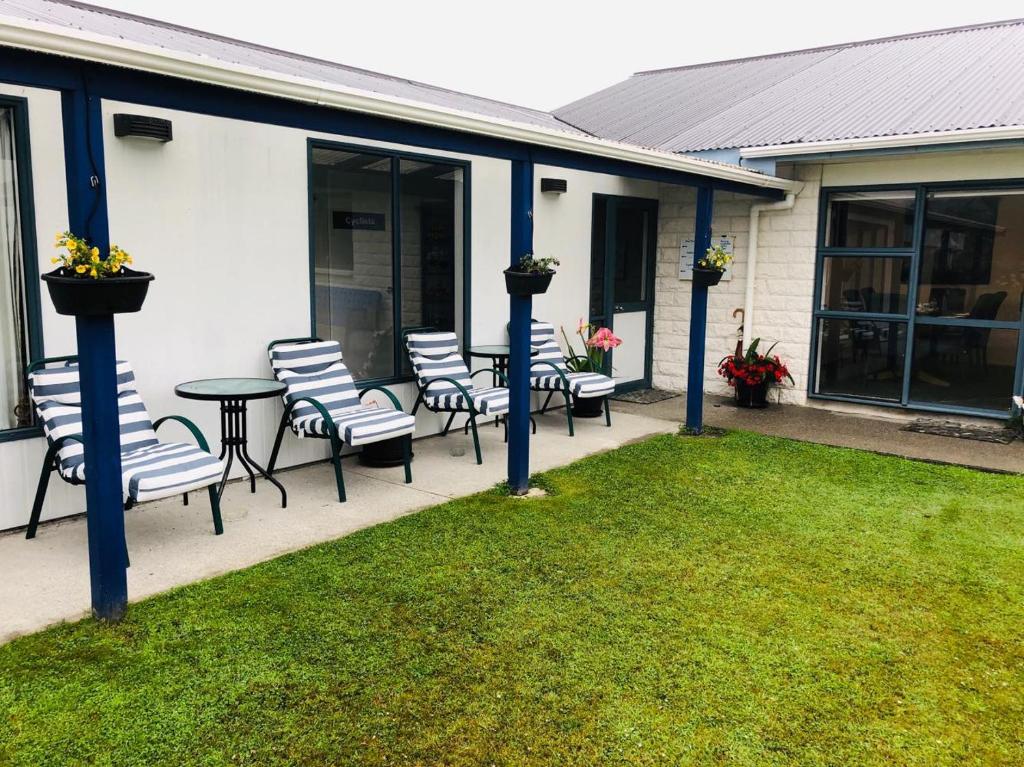 a patio with chairs and a table in front of a house at Hokitika - Blue Spur Bed and Breakfast in Hokitika