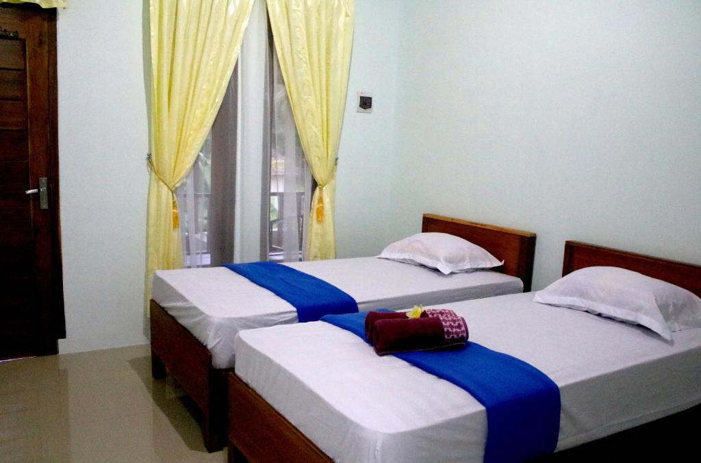 En eller flere senge i et værelse på Arrys Watukarung Surfcamp