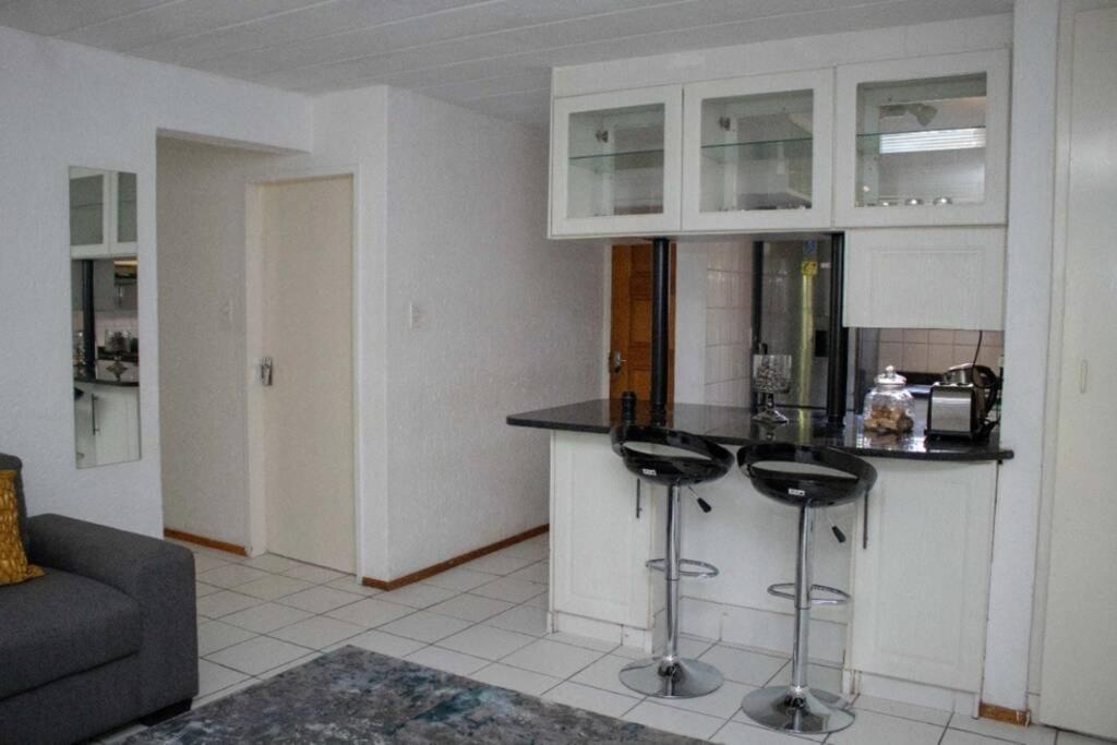 a kitchen with a counter and stools in a room at Phil's Place in Johannesburg