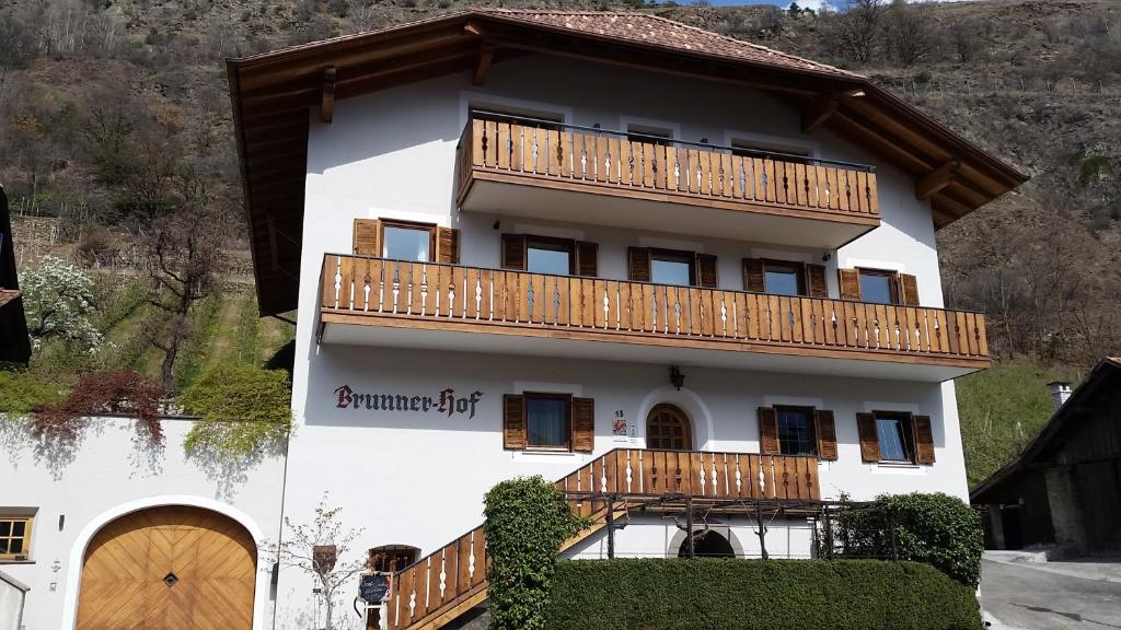 un gran edificio blanco con balcones de madera en Brunnerhof en Naturno