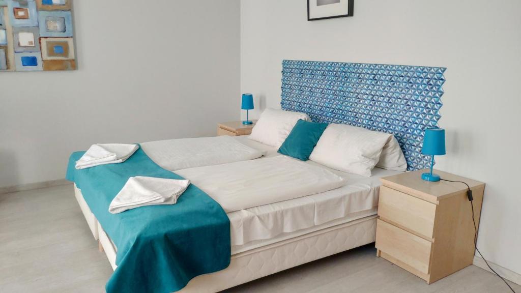 a bedroom with a bed with a blue headboard at Agape Apartments in Budapest