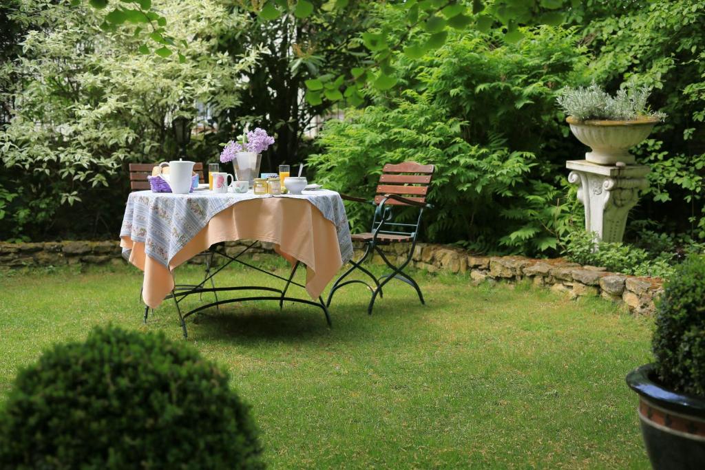 a table in a garden with a table and chairs at Hotel Weingewolbe in Bermersheim