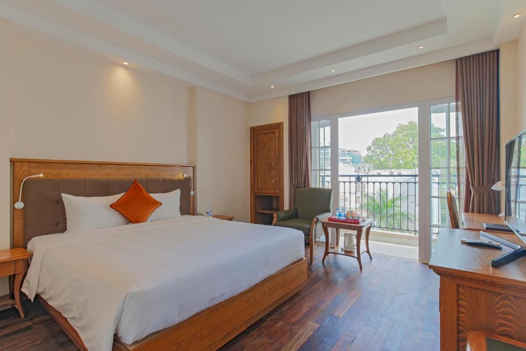 a bedroom with a bed and a desk and a window at Hoang Lan Hotel in Ho Chi Minh City