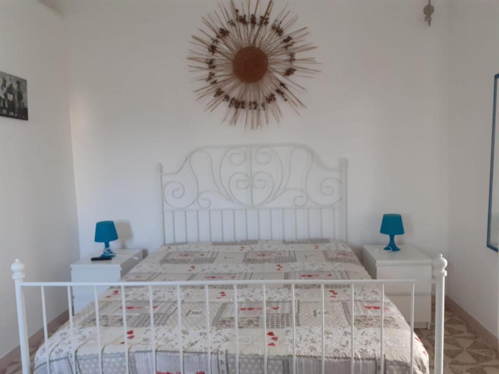 una camera con un letto bianco e uno specchio a parete di La Talega a Otranto
