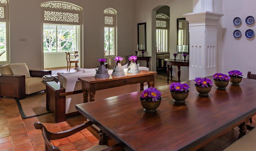 a living room with a table with purple flowers on it at Nyne Hotels Rock Villa, Bentota in Bentota