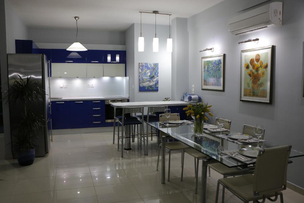 cocina con armarios azules, mesa y sillas en Laconian Collection "Lykourgou 10", en Esparta