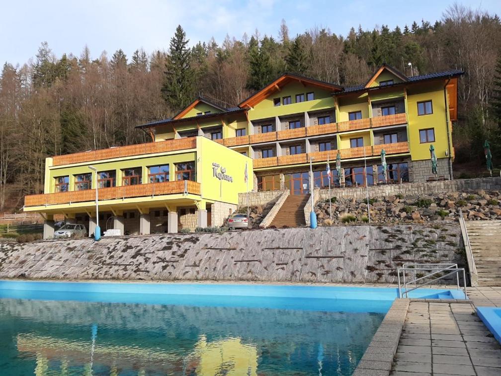 un hôtel avec une piscine d'eau en face d'un bâtiment dans l'établissement Relax Kycera, à Prostřední Bečva