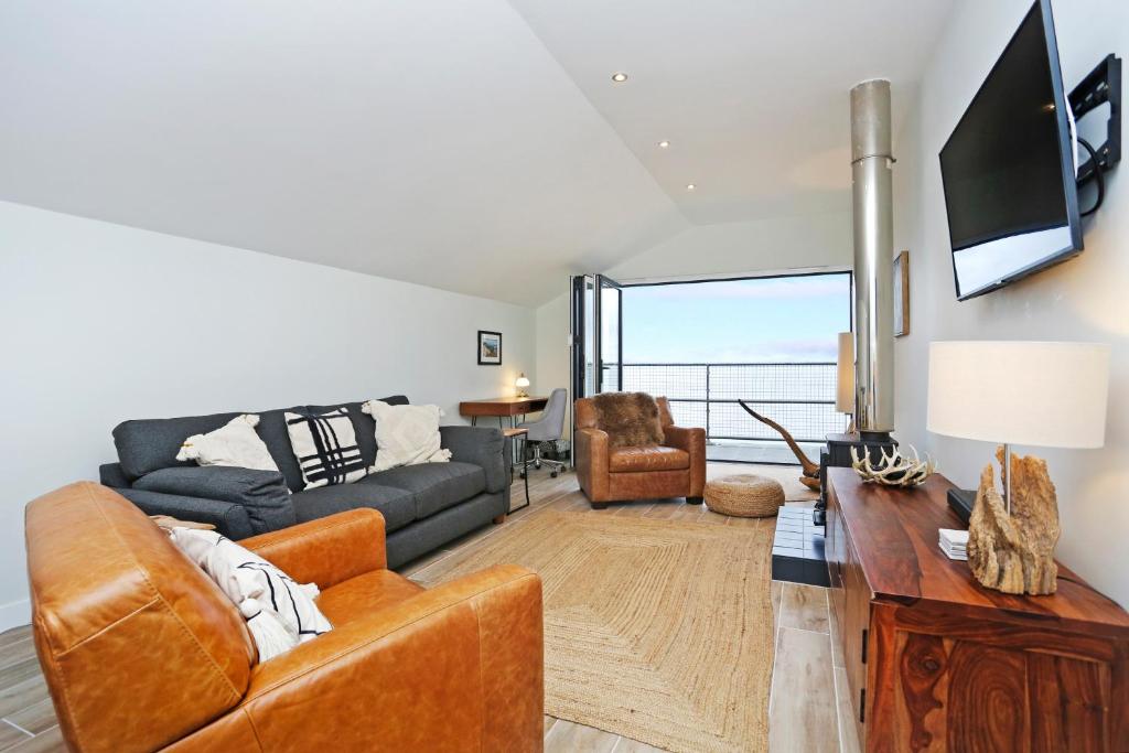 a living room with a couch and a tv at Musselburgh - Stylish 3 bed with Stunning Sea Views in Edinburgh