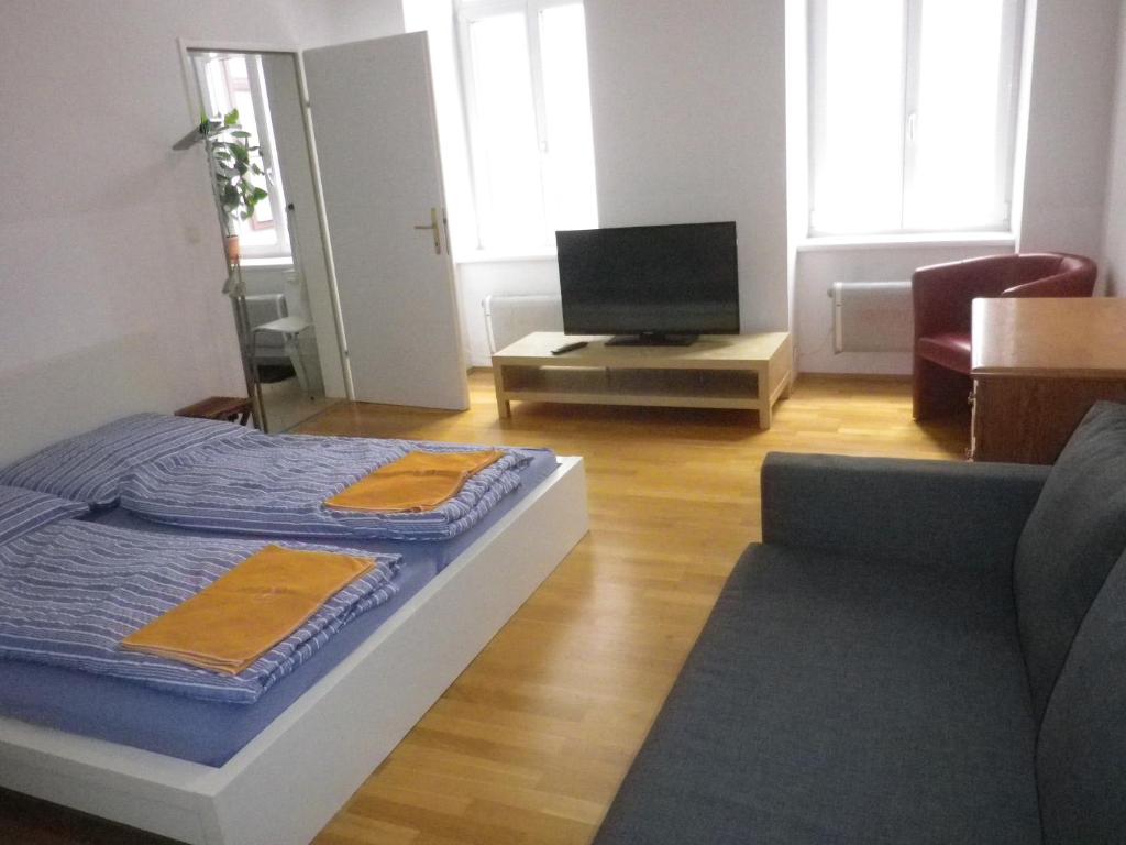 Sala de estar con cama y TV en Apartment Dahlia, en Viena