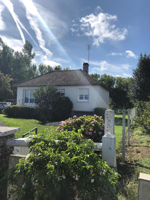 une maison avec une clôture et des fleurs dans la cour dans l'établissement La maison d’Henri, à Sailly-Flibeaucourt