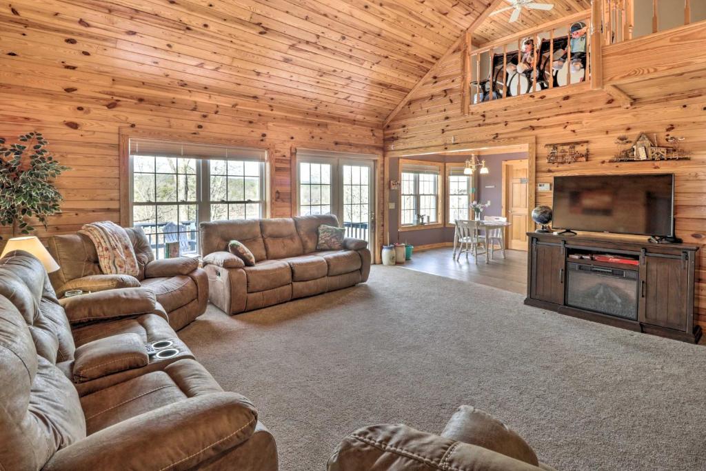 a living room with couches and a television in a cabin at Lakeside Hot Springs Retreat with Kayaks and Boat Dock in Hot Springs Village