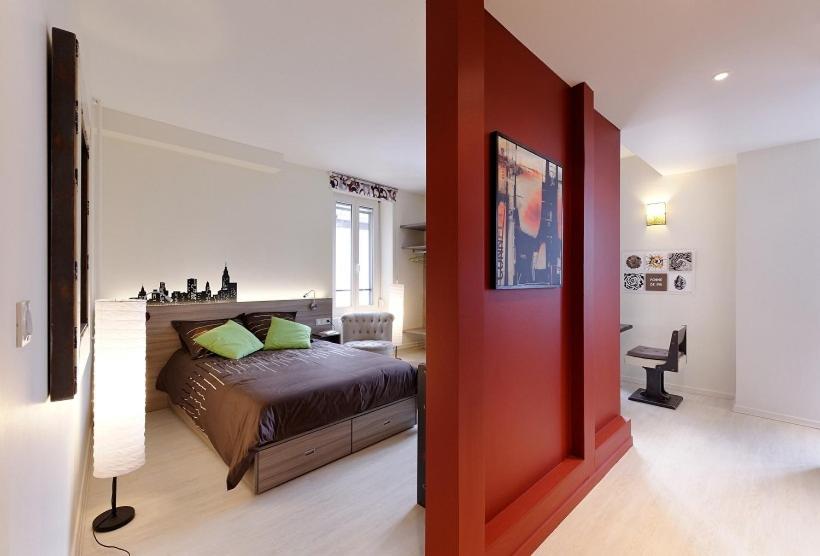 a bedroom with a bed and a red wall at Appartement Quai N° 5 in Strasbourg