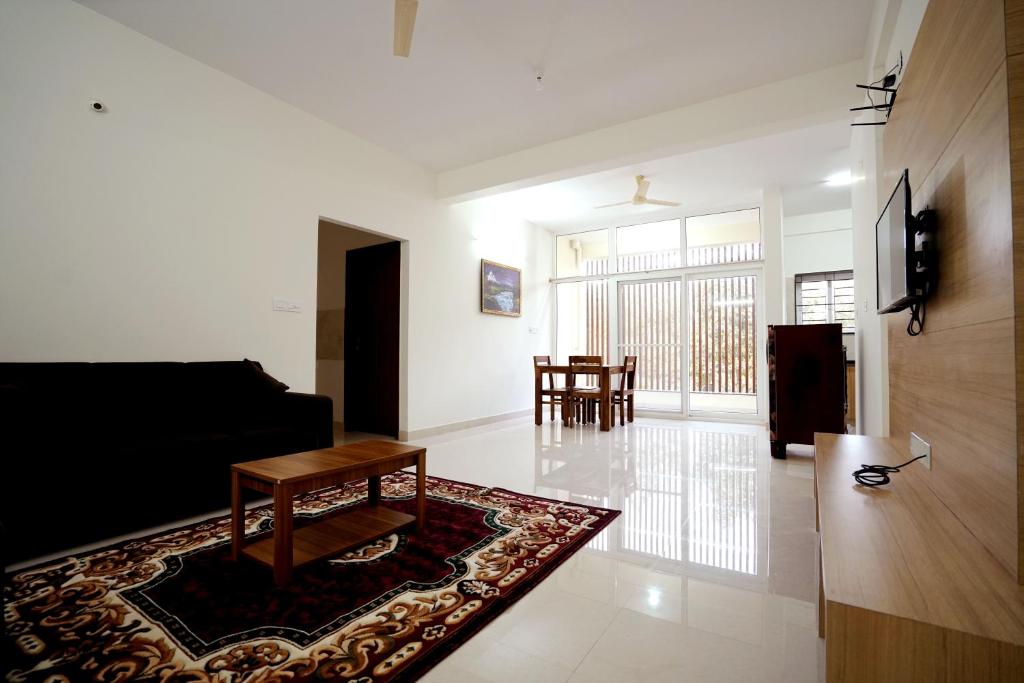 a living room with a black couch and a table at Castle JP Service Apartments in Bangalore