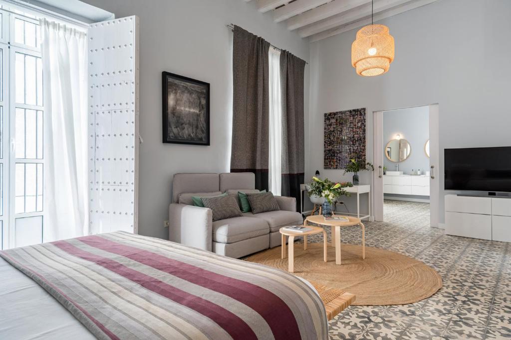 a bedroom with a bed and a living room at Art Suites by Casa de Indias in El Puerto de Santa María