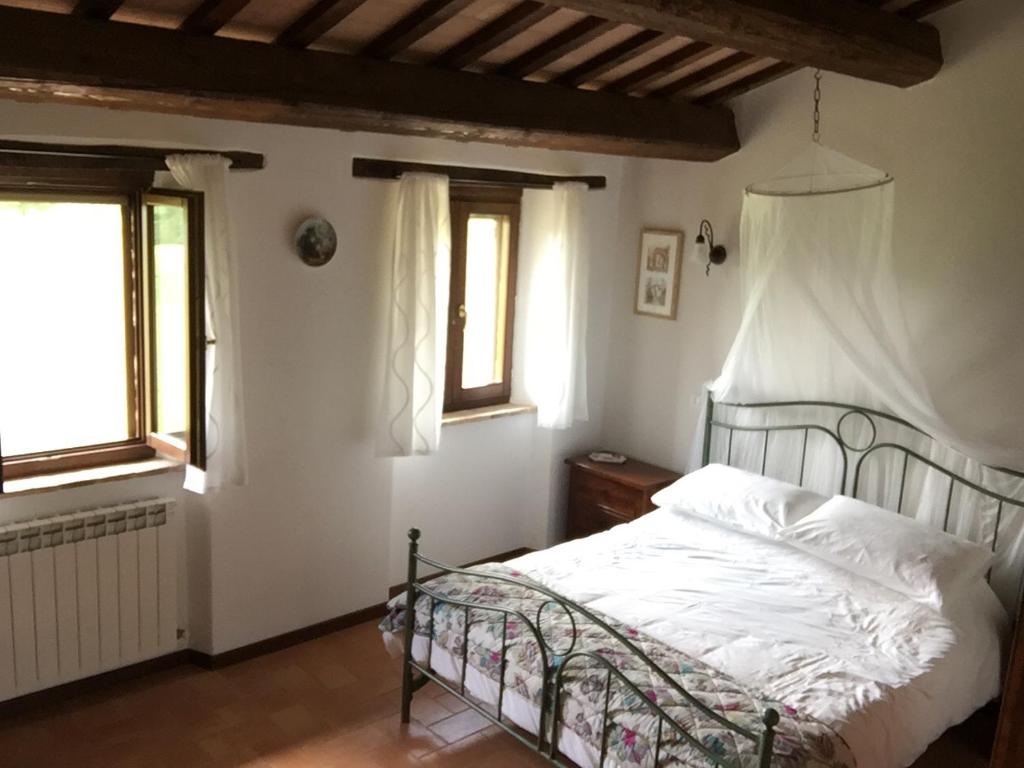 um quarto com uma cama e duas janelas em Casa Edera em Montelparo