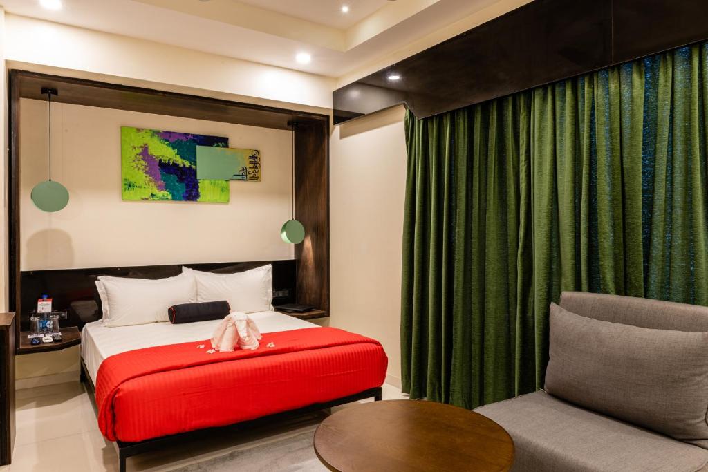 Schlafzimmer mit einem Bett und einer roten Ottomane in der Unterkunft Little Mastiff Moshi by OTHPL in Pune