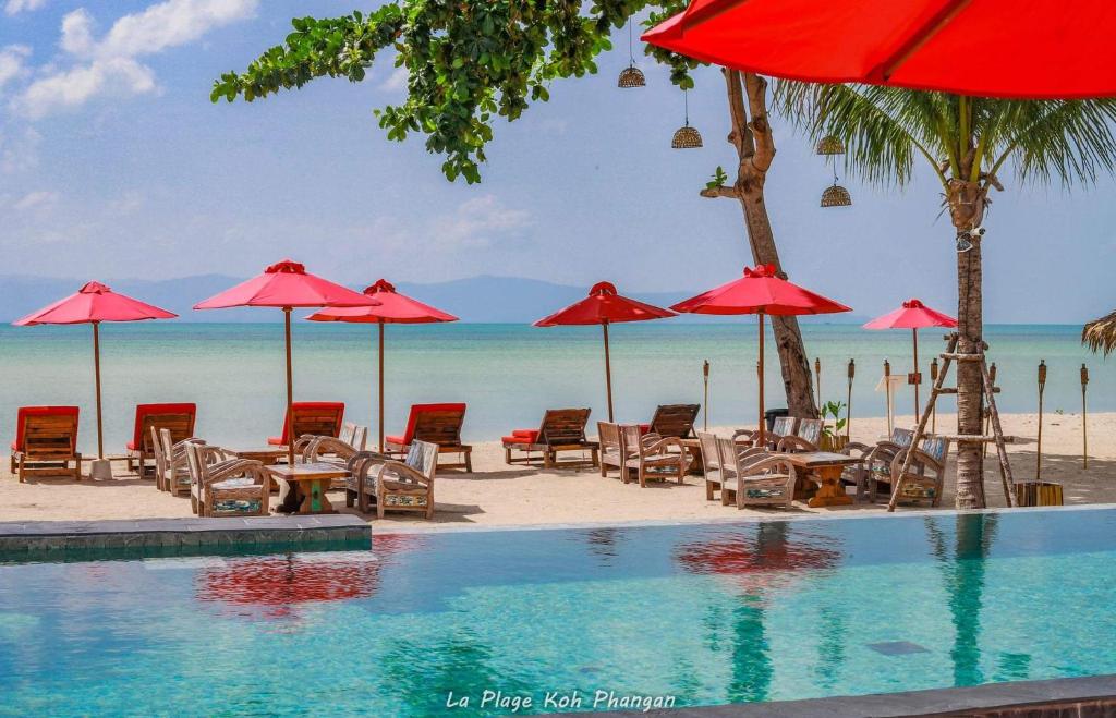basen z leżakami i parasolami na plaży w obiekcie la plage resort & beach club w mieście Baan Tai