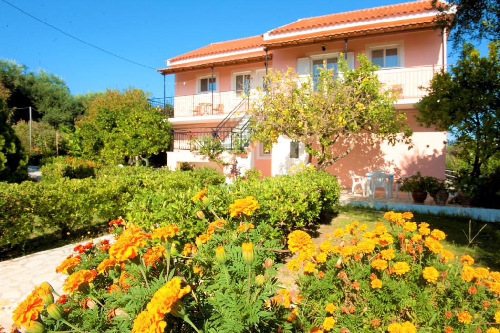 a garden in front of a house with flowers at Maria's Paradise in Astrakeri