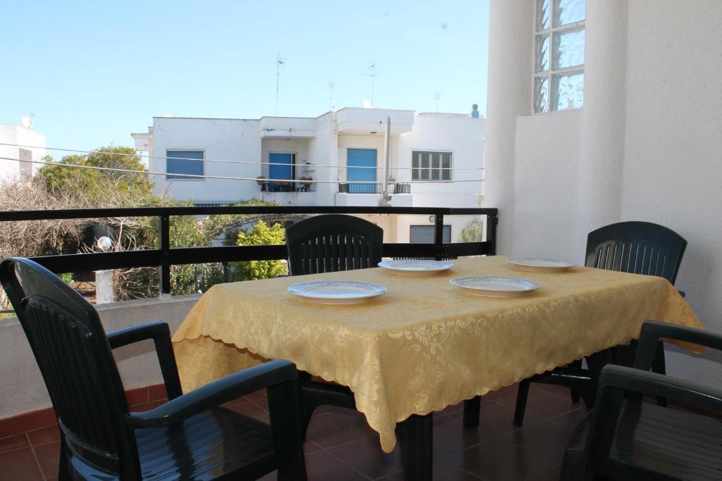 een tafel met een geel tafelkleed op een balkon bij Villetta Leo in Baia Verde in Il Monte
