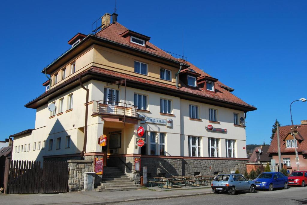 a large white building on the corner of a street at Hotel Chata in Volary