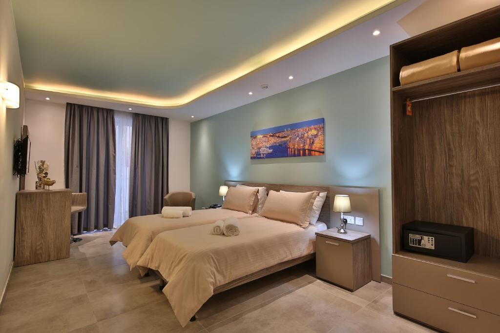1 dormitorio con 1 cama grande y TV en Lokali Rooms, en Il-Gżira