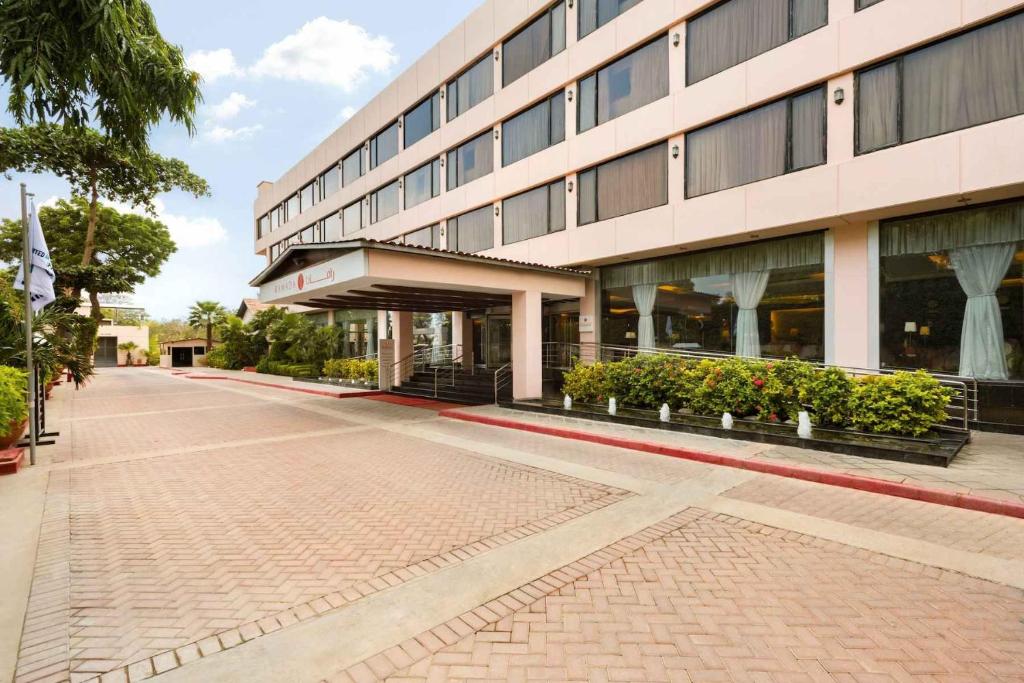 a building with a brick sidewalk in front of it at Ramada Plaza by Wyndham Karachi Airport Hotel in Karachi