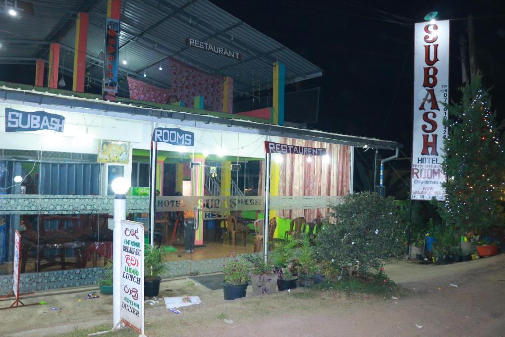 a store with signs in front of it at night at Subash Hotel in Nallathanniya