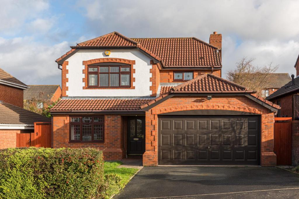 a red brick house with a garage at Drayton Manor House FREE parking in Tamworth