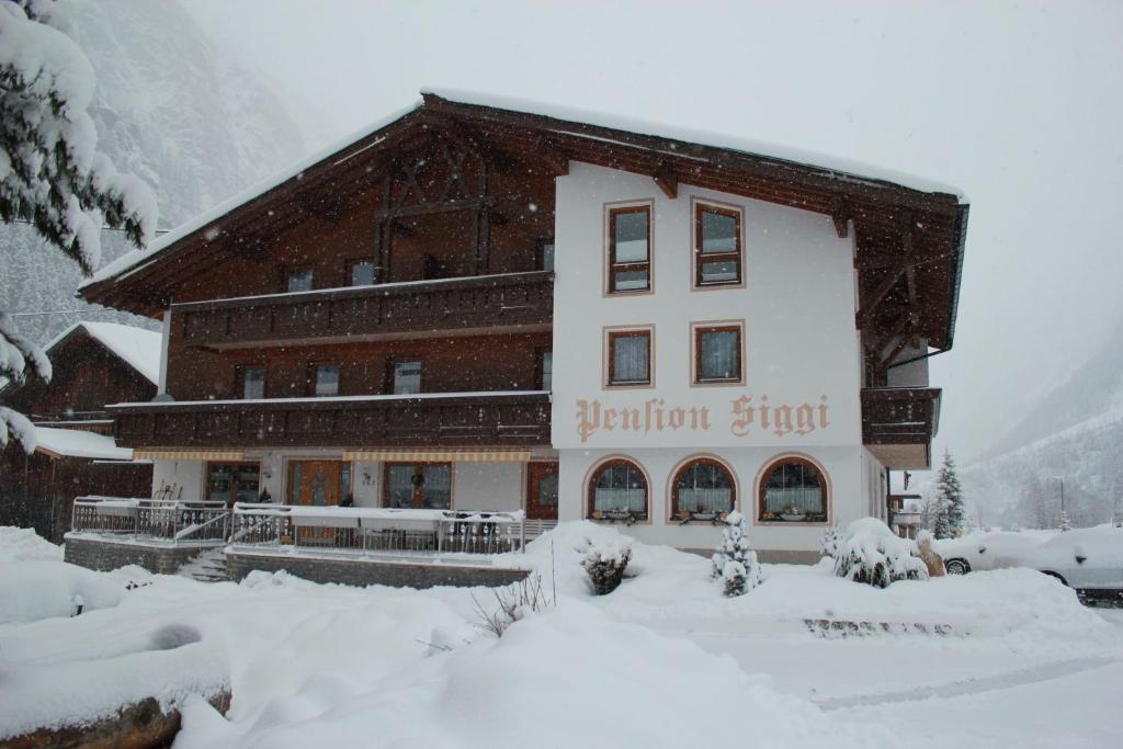 ein großes Gebäude mit Schnee auf dem Boden in der Unterkunft Hotel Pension Siggi in Sankt Leonhard im Pitztal