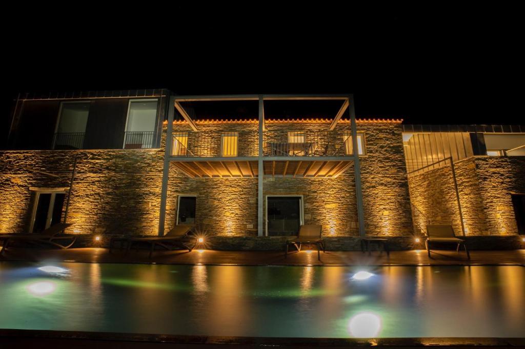 a building with a swimming pool at night at CASA QTA. STA. CRUZ-RÉGUA in Peso da Régua