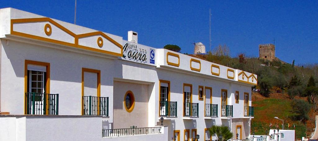 a white building with a sign on top of it at Hotel Louro in Óbidos